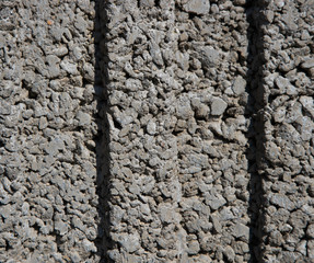 texture of a wall of small, small gray stones with two dimples in the middle