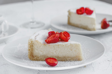 Cheesecake decorated with strawberries on a white plate