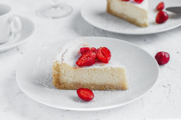 Cheesecake decorated with strawberries on a white plate