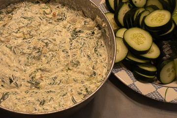 fresh spinich dip near plate of green vegetables on table