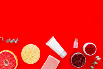 Natural herbal cosmetics with grapefruit on red background top view space for text