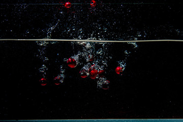 cranberries falling in dark water with splashes © Martins Vanags