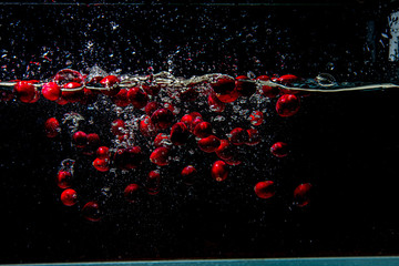 cranberries falling in dark water with splashes © Martins Vanags