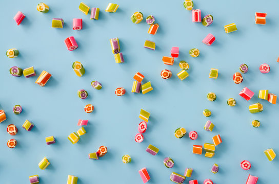 Scattered multicolored sugar candy on a blue background