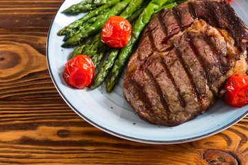 Grilled beef steak ribeye with cherry tomatoes and asparagus