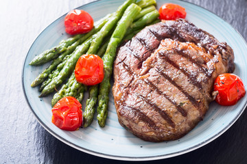 Grilled beef steak ribeye with cherry tomatoes and asparagus