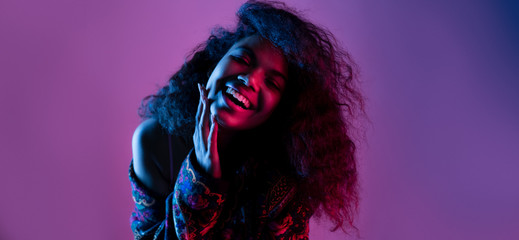 Happy smiling fashion young african girl black woman wear stylish jacket looking at camera laughing isolated on party disco purple studio background, banner for website design, portrait, copy space