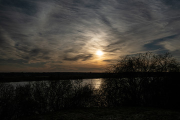 dramatic dark red clouds in sunset over countryside fields and forests