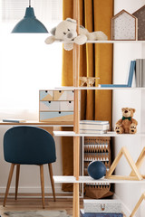 Workspace with desk and chair in elegant teenager's room with blue and orange design