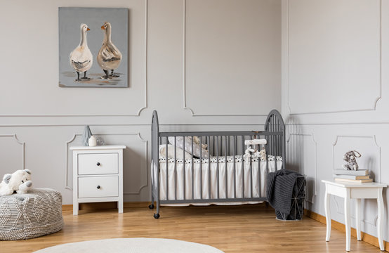 Trendy grey baby room design in tenement house, copy space on empty wall