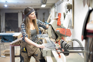 young woman working in carpenter's workshop