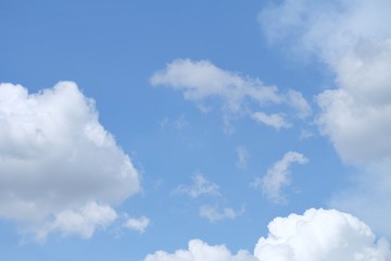 Blue sky with white fluffy clouds in bright day for background texture 
