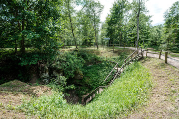 archeological pit cave in the ground in meadow