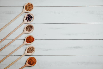 Top view on a set of spices on a wooden table. The concept of using seasonings for dishes, various spices on wooden spoons.