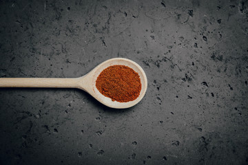 Ground red peppers on a stone table. The concept of using seasonings for dishes. Strengthening the taste through spices, better cooking and better taste of dishes.