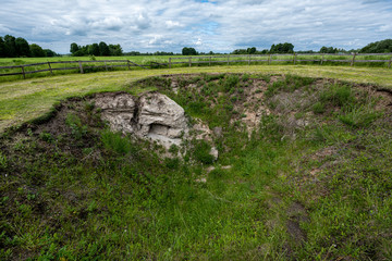 Fototapeta na wymiar archeological pit cave in the ground in meadow