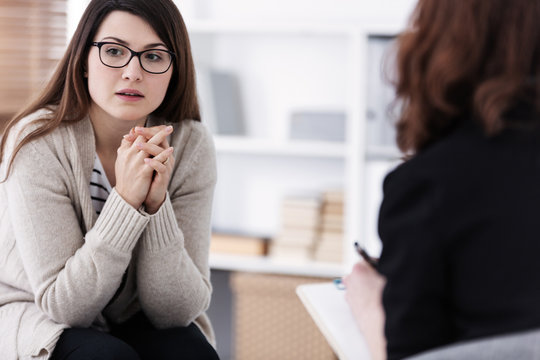 Sad girl with psychotherapist. Women's issues support group concept