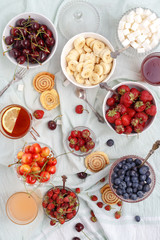 Summer berries strawberries, blueberries, sweet cherries in vases on the table. Top view