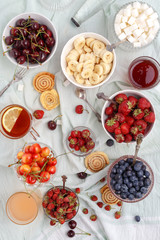 Summer berries strawberries, blueberries, sweet cherries in vases on the table. Top view