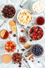 Summer berries strawberries, blueberries, sweet cherries in vases on the table. Top view