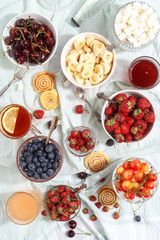 Summer berries strawberries, blueberries, sweet cherries in vases on the table. Top view