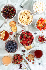 Summer berries strawberries, blueberries, sweet cherries in vases on the table. Top view