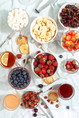 Summer berries strawberries, blueberries, sweet cherries in vases on the table. Top view
