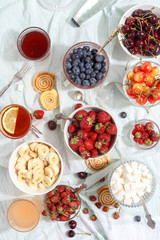 Summer berries strawberries, blueberries, sweet cherries in vases on the table. Top view
