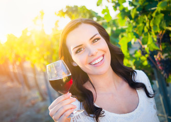 Beautiful Young Adult Woman Enjoying Glass of Wine Tasting In The Vineyard