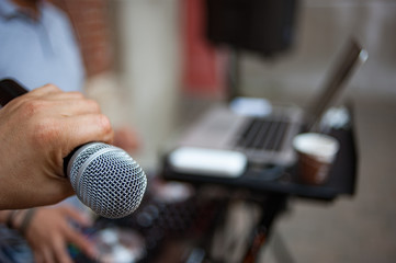 A microphone in the hand at a live outdoor party.