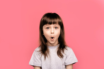 Wow! Surprise and shock. It's amazing news. Little child girl showing overjoy emotions over pink studio background. Human emotions, lifestyle, freestyle, smile, blank, funny gesture.