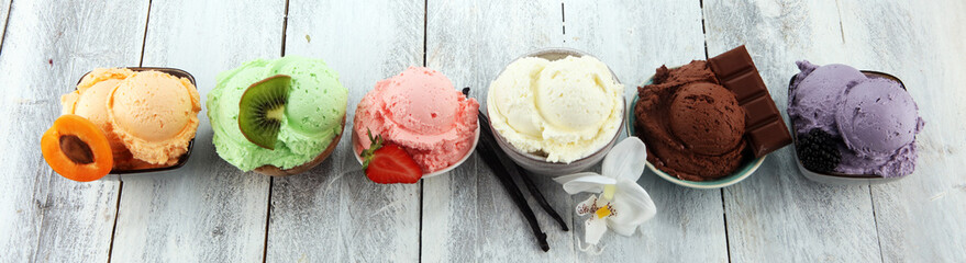ice cream scoops of different colors and flavours with berries, nuts and fruits decoration on white background