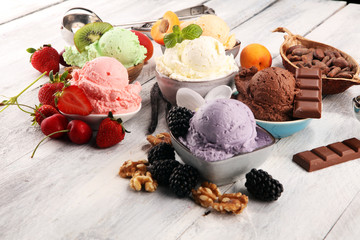 ice cream scoops of different colors and flavours with berries, nuts and fruits decoration on white...