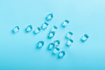 Ice cubes on blue background. Flat lay, top view