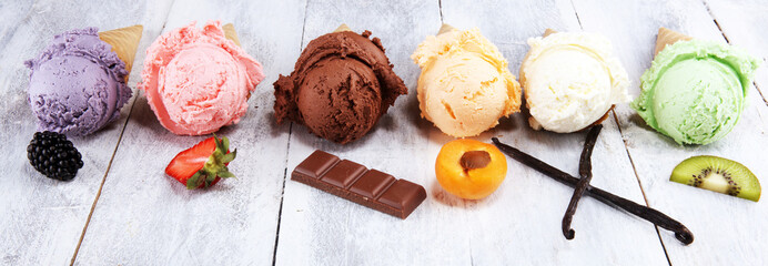 ice cream scoops of different colors and flavours with berries, nuts and fruits decoration on white background