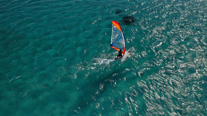 Aerial photo of surfer cruising in high speed in Mediterranean destination bay with deep blue sea