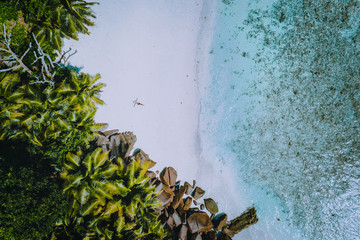 Aerial view of a young woman with on the tropical paradise beach. Crystal clear water, summer luxury exotic romantic vacation, honeymoon