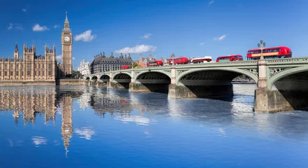 Schilderijen op glas Big Ben and Houses of Parliament with red buses on the bridge in London, England, UK © Tomas Marek