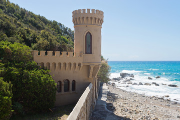 Castle near beautiful azure sea and the rocky beach