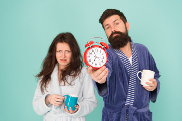 Its coffee time. Man with beard and sleepy woman enjoy morning coffee or tea. Guy in bath clothes...