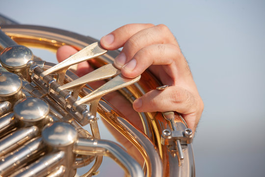 French horn instrument. Player hands playing horn music brass instrument