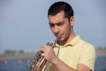French horn player playing music instrument Man hornist classical musician
