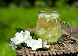 Cup of jasmine tea and jasmine flowers
