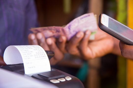 closeup of hand using mobile phone and exchanging money