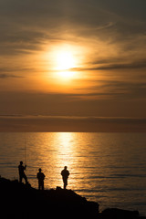 夕暮れの海と釣り人たち