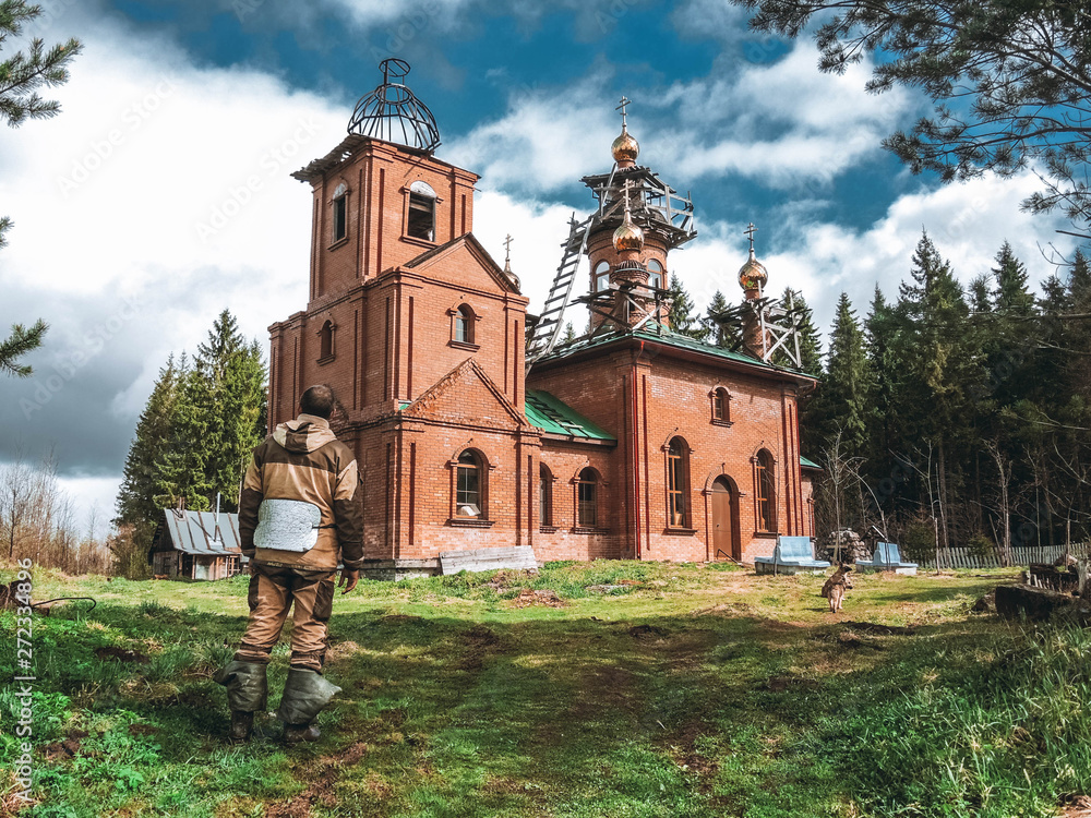 Wall mural man and old church in russia