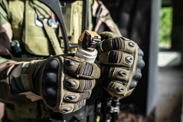 Close up on SWAT special military police force holding shock grenade ready to activate in combat...