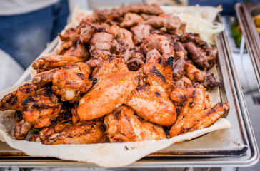Barbecue roasted tasty chicken wings with herbs and sauce on the tray. Outdoors Food/Juicy fried chicken wings