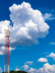 telecommunication tower on bright blue and cloudy sky