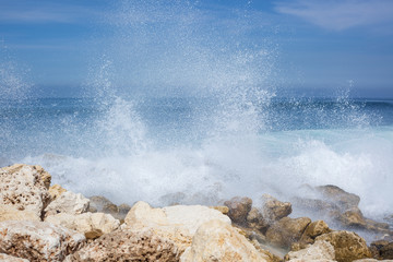 sea view. blue ocean, big waves, black and white stones, high tide, water splash